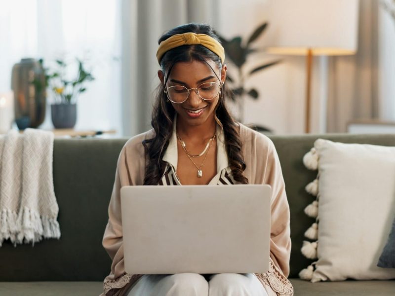 laptop remote work and happy woman on a sofa for social media research or reading a home tech f